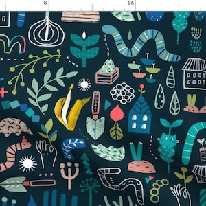 May include: A dark blue fabric with a whimsical pattern featuring a variety of shapes, colours, and textures. The pattern includes houses, plants, bananas, snakes, and other abstract designs.