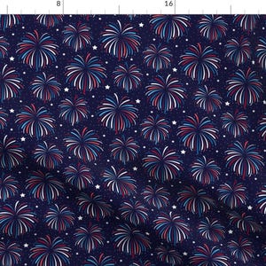 May include: A navy blue fabric with a repeating pattern of red, white, and blue fireworks. The fireworks are stylized and resemble a burst of light.