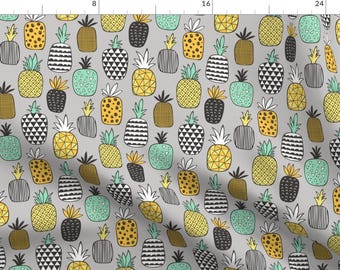 May include: A seamless pattern featuring a variety of pineapple designs in yellow, green, black, and white on a gray background.