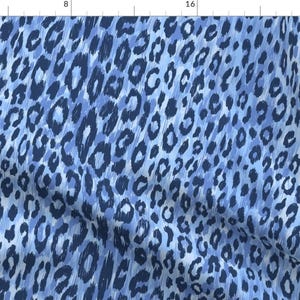 May include: Blue and white leopard print fabric with a brushed texture.