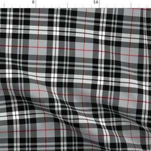 May include: A black, white, and gray plaid fabric with thin red stripes. The fabric is folded and has a slight wrinkle.