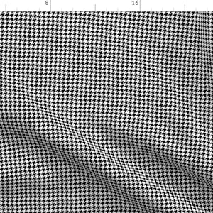 Könnte beinhalten: Schwarz-weißes Hahnentrittmuster mit einem subtilen Diagonalmuster. Der Stoff ist glatt und hat einen leichten Glanz.