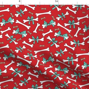 May include: A red background with a repeating pattern of white dog bones and teal blue bows.