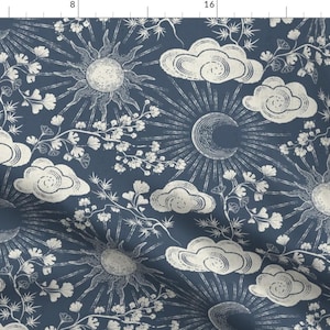 Könnte beinhalten: Dunkelblauer Stoff mit einem sich wiederholenden Muster aus Sonnen, Monden, Wolken und floralen Elementen in Off-White. Die Sonnen haben Strahlen, und die Wolken sind aufgebläht. Das Design erinnert an himmlische und botanische Themen.