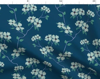 Puede incluir: Una tela azul teal con un patrón floral blanco. Las flores son estilizadas y tienen un aspecto delicado, dibujado a mano.
