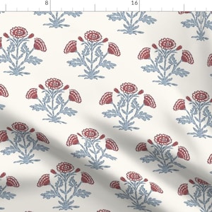 Puede incluir: Tela de color crema con un patrón repetido de ramos de flores estilizados. Cada ramo presenta una flor roja central con hojas azul-gris y pequeños acentos rojos. El diseño está espaciado uniformemente en la tela.