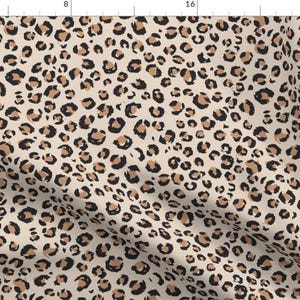 Pode incluir: Um padrão sem costura com um fundo bege e um padrão repetido de manchas de leopardo pretas e marrons.