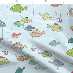 May include: A light blue background with a repeating pattern of colorful cartoon fish. The fish are all different shapes and sizes, and some have polka dots, stripes, or other patterns. There are also some bubbles and fishing lines with worms on the ends.