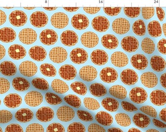 May include: A seamless pattern featuring alternating brown and yellow waffles on a light blue background. The waffles have a grid pattern and some have a pat of butter on top.