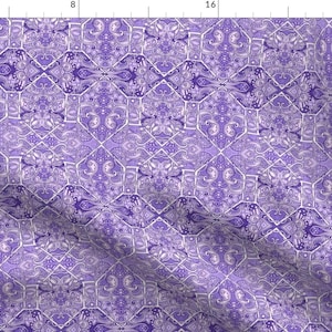 May include: Purple and white paisley patterned fabric with a repeating geometric design.
