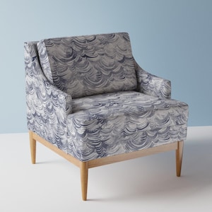 May include: A blue and white patterned armchair with wooden legs. The chair has a high back and a comfortable seat.
