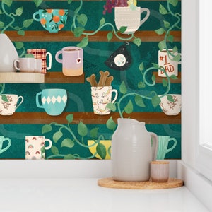 Puede incluir: Un fondo verde azulado con un estante lleno de varias tazas, jarras y cuencos. El estante está decorado con enredaderas y hojas. El estante está sobre una superficie blanca con una jarra blanca y un pequeño frasco.