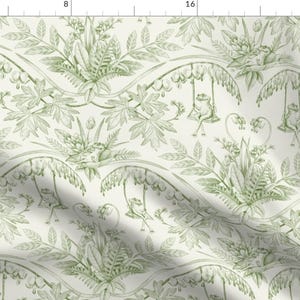 May include: A fabric with a repeating pattern of green frogs on swings, surrounded by foliage. The design has a vintage, botanical aesthetic, with a light cream background and detailed illustrations. The overall theme is whimsical and nature-inspired.