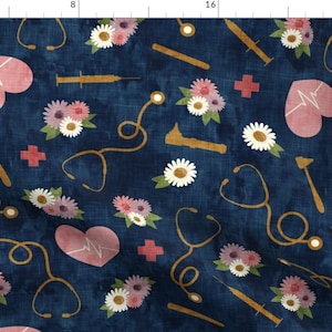 以下が含まれることがあります： 紺色の生地に、医療用シンボルとピンクのハートが繰り返し描かれたパターン。シンボルには、聴診器、注射器、反射ハンマー、十字架が含まれています。ハートには白い心電図の線が描かれています。