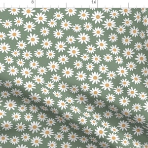 Puede incluir: Una tela verde con un patrón de margaritas blancas. Las margaritas tienen un centro amarillo.