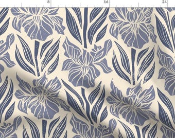 May include: Fabric featuring a floral design with irises and leaves in blue and white on a cream backdrop. The pattern has a block print style, giving a textured look. The fabric is suitable for craft projects. Measurements are in cm.