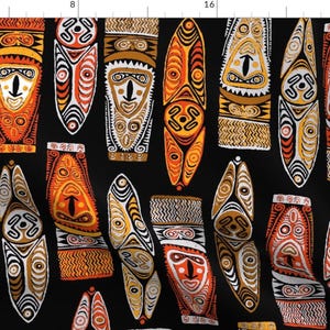 May include: A black background with a repeating pattern of colorful, stylized masks. The masks are in shades of orange, yellow, white, and brown. The masks have geometric designs and are reminiscent of tribal art.
