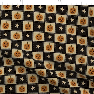 Puede incluir: Un patrón de tela con un diseño de tablero de ajedrez repetitivo de cuadrados negros y cuadrados de color crema. Cada cuadrado crema contiene una calabaza naranja, mientras que cada cuadrado negro presenta una pequeña estrella blanca de cinco puntas.