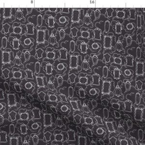 May include: A black fabric with a white pattern of various frames and mirrors. The pattern is repeated throughout the fabric.