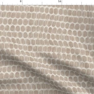 Puede incluir: Tela con un patrón repetitivo de formas ovaladas en tonos beige y topo. El diseño está dispuesto en filas horizontales, creando un efecto texturizado. Adecuado para proyectos de manualidades y costura, con una paleta de colores neutros.