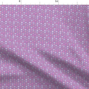 May include: A purple fabric with a repeating pattern of small pink and white hearts.