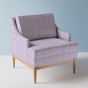 May include: A lilac armchair with a geometric pattern. The chair has a light wood frame and legs. The seat and back cushions are upholstered in a patterned fabric. The chair is designed for comfort and style.