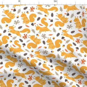 May include: A white background with a repeating pattern of yellow squirrels, acorns, and leaves. The squirrels are in various poses, some holding acorns, some jumping, and some running.