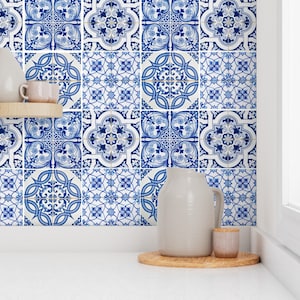 May include: Blue and white patterned tile stickers with a traditional Portuguese design. The stickers are arranged in a grid pattern and are displayed on a white wall in a kitchen setting.