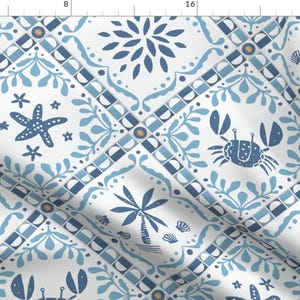 May include: A white fabric with a repeating pattern of blue and white tiles. The tiles feature a variety of sea life, including starfish, crabs, and palm trees. The pattern is reminiscent of traditional Portuguese tiles.