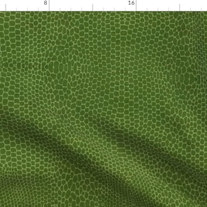 May include: Green fabric with a repeating pattern of small, irregular shapes, creating a textured appearance. The design is a darker shade of green, providing contrast against the lighter green background. The fabric is likely suitable for various crafting projects.