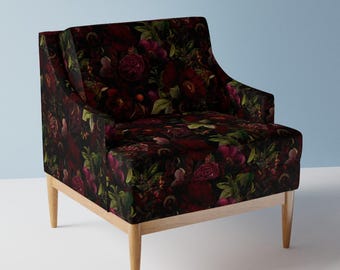 May include: Upholstered armchair with a dark floral pattern featuring red and purple roses on a black background. The chair has a light wood frame and legs, offering a contrast to the dark fabric.