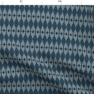 May include: A repeating pattern of dark blue diamonds on a light blue background. The diamonds are outlined in white and have a small white dot in the center.