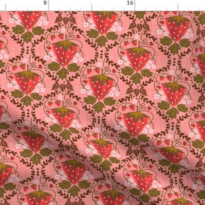 Pode incluir: Um tecido rosa com um padrão repetido de morangos vermelhos, folhas verdes e flores brancas. Os morangos estão dispostos em forma de diamante.