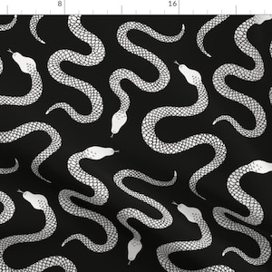 Pode incluir: Tecido preto com um padrão repetido de cobras brancas. As cobras têm escamas detalhadas e cabeças brancas, contrastando com o fundo escuro. Este design é adequado para roupas e decoração de casa.