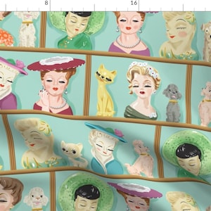 Può includere: Un motivo ripetuto di figurine in ceramica in stile vintage su uno sfondo blu chiaro. Le figurine rappresentano donne con diverse acconciature e cappelli, e alcune tengono animali come gatti, cani e uccelli. Le figurine sono disposte su mensole con una cornice in legno.