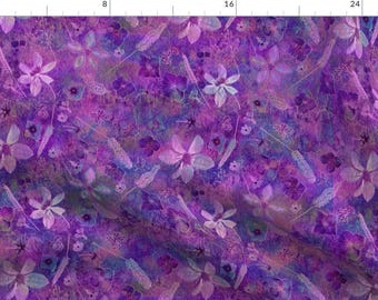 Op de afbeelding: Een paars en blauw bloemenpatroon met een aquareleffect. De bloemen zijn wit en hebben een delicate, etherische uitstraling.