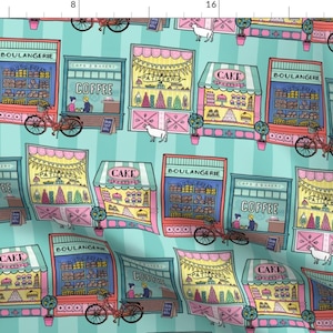 May include: A repeating pattern of colorful storefront illustrations featuring various French bakery and cafe shops. The shops are decorated with flags, bunting, and bicycles. The background is a turquoise blue with white stripes.