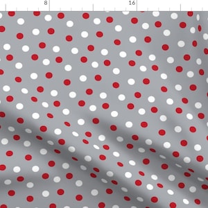 May include: A gray fabric with a repeating pattern of red and white polka dots.