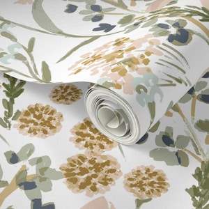 May include: A roll of wallpaper with a floral design. The pattern showcases watercolour-style flowers in gold, pink, blue, and green on a white backdrop. The roll is partially unrolled, displaying the pattern.