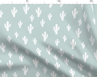 May include: A seamless pattern featuring white cactus silhouettes on a light blue background. The cactus shapes are simple and stylized, creating a modern and minimalist design.