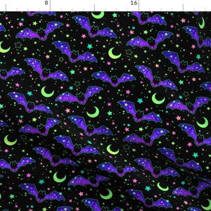 Puede incluir: Una tela negra con un patrón repetido de murciélagos morados con estrellas y lunas crecientes de color verde neón, rosa y azul.