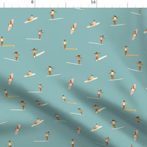 May include: A seamless pattern featuring a repeating design of women surfing on a turquoise blue background. The women are illustrated in a simple style with brown skin, and are wearing various swimwear. The surfboards are pink and yellow.
