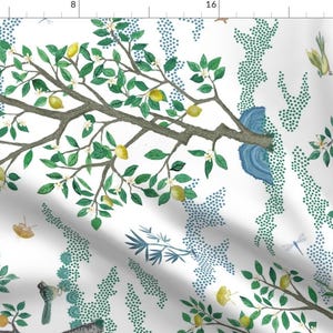 May include: A white fabric with a repeating pattern of a lemon tree with green leaves, yellow lemons, and white flowers. The background is white with blue and green dots.