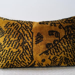 May include: A rectangular throw pillow featuring a mustard yellow velvet fabric base. The surface is decorated with an intricate, dense pattern of black embroidered lines and stitching that creates a textured, repeating geometric design across the front.
