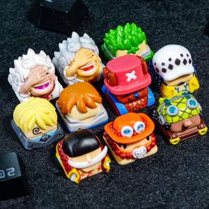 Peut inclure: Un ensemble de dix touches de clavier color&eacute;es repr&eacute;sentant des personnages de la s&eacute;rie d'anime populaire One Piece. Les touches sont en plastique et pr&eacute;sentent une vari&eacute;t&eacute; de motifs, notamment Luffy, Zoro, Sanji et Chopper.