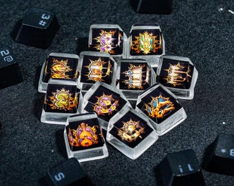 May include: A collection of 12 keycaps with various colorful designs, including a skull, a dragon, and a flower. The keycaps are made of clear plastic and have a glossy finish.
