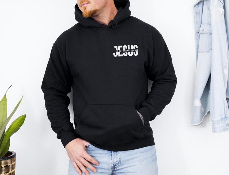 May include: Black hoodie with the word "JESUS" printed in white on the chest. The text "THE WAY - THE TRUTH - THE LIFE" is printed below the word "JESUS". The sweatshirt has a front pocket and long sleeves.
