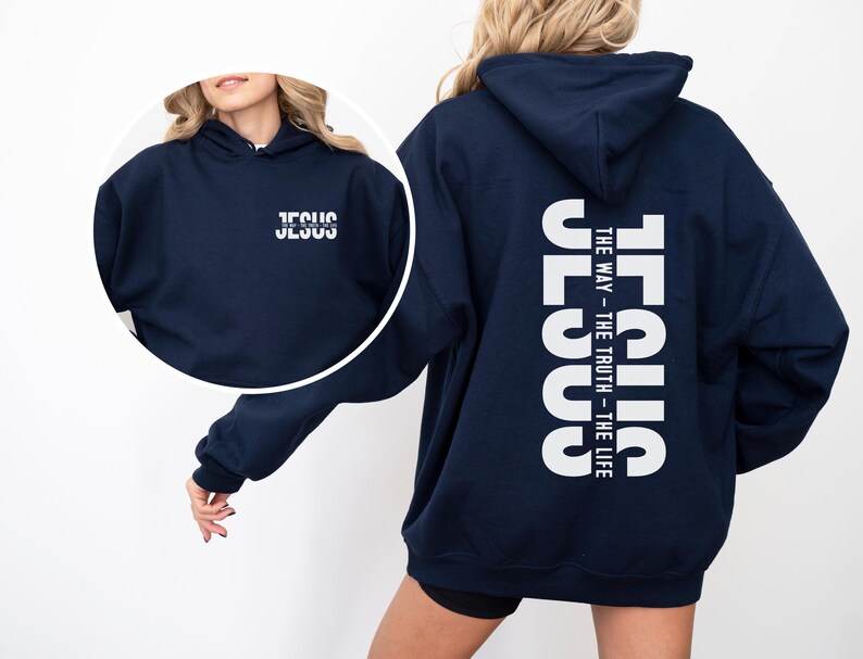 May include: Navy blue hoodie with white text. The front of the hoodie has the word "JESUS" printed in white. The back of the hoodie has the word "JESUS" vertically, with "THE WAY - THE TRUTH - THE LIFE" printed below.