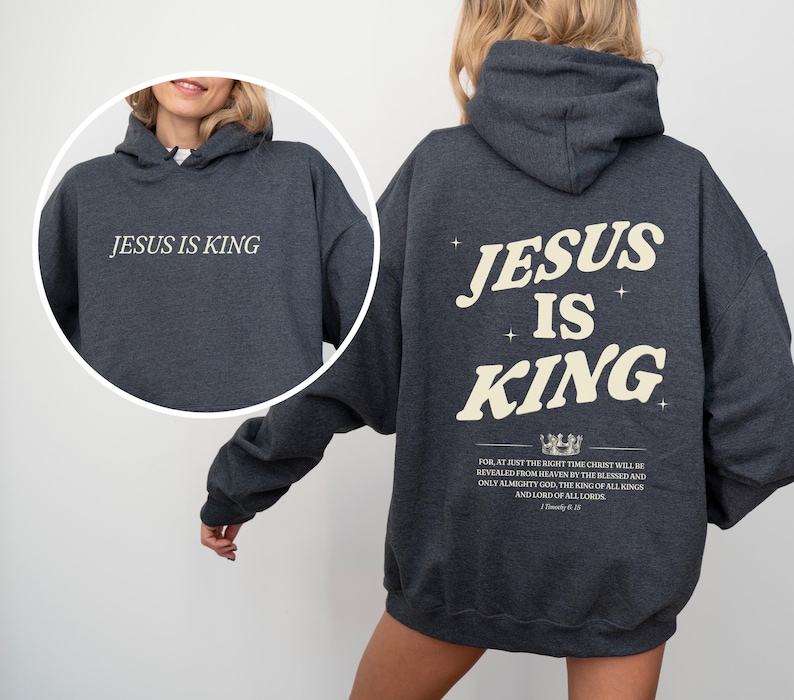 May include: Dark gray hoodie with the text "JESUS IS KING" on the front and back. The back design includes the text "JESUS IS KING" in a stylized font, along with additional text and a crown graphic.