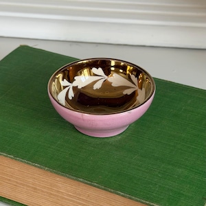 May include: A white ceramic mug with a black handle and the text "But First, Coffee" in a handwritten style. The mug is on a white surface. The mug is approximately 4 inches tall.